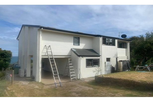 A white house with a professionally done garage door.